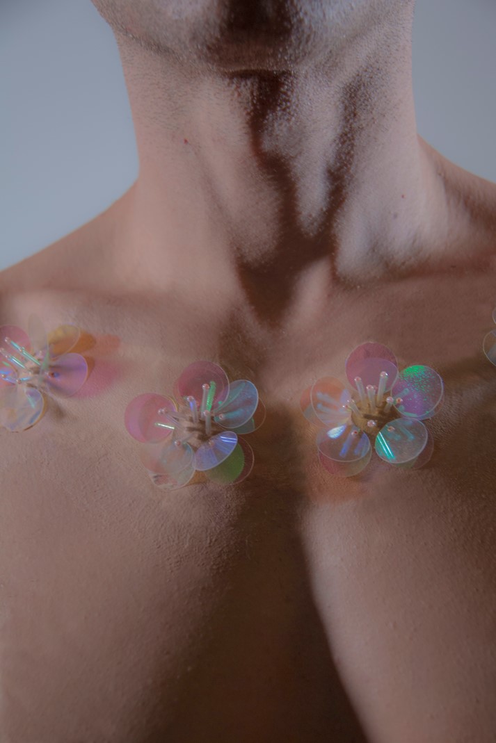 Model flowers adorning a bare chest
